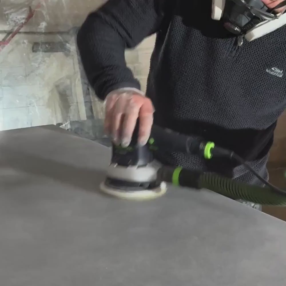 Steve Sanding Polished Concrete Dining Table In Workshop