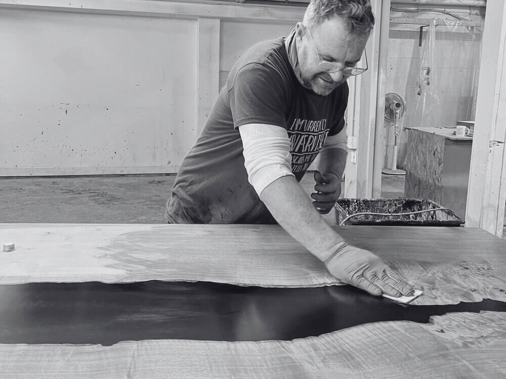 steve sealing a black resin river dining table