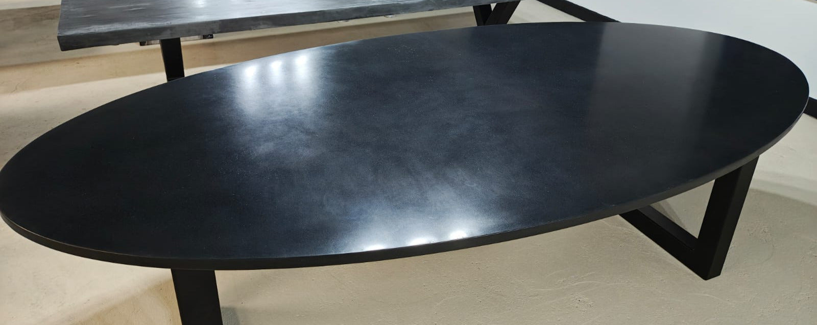 RockVine Artisan Surfaces Black polished concrete dining table in a room with white walls and tiled floor