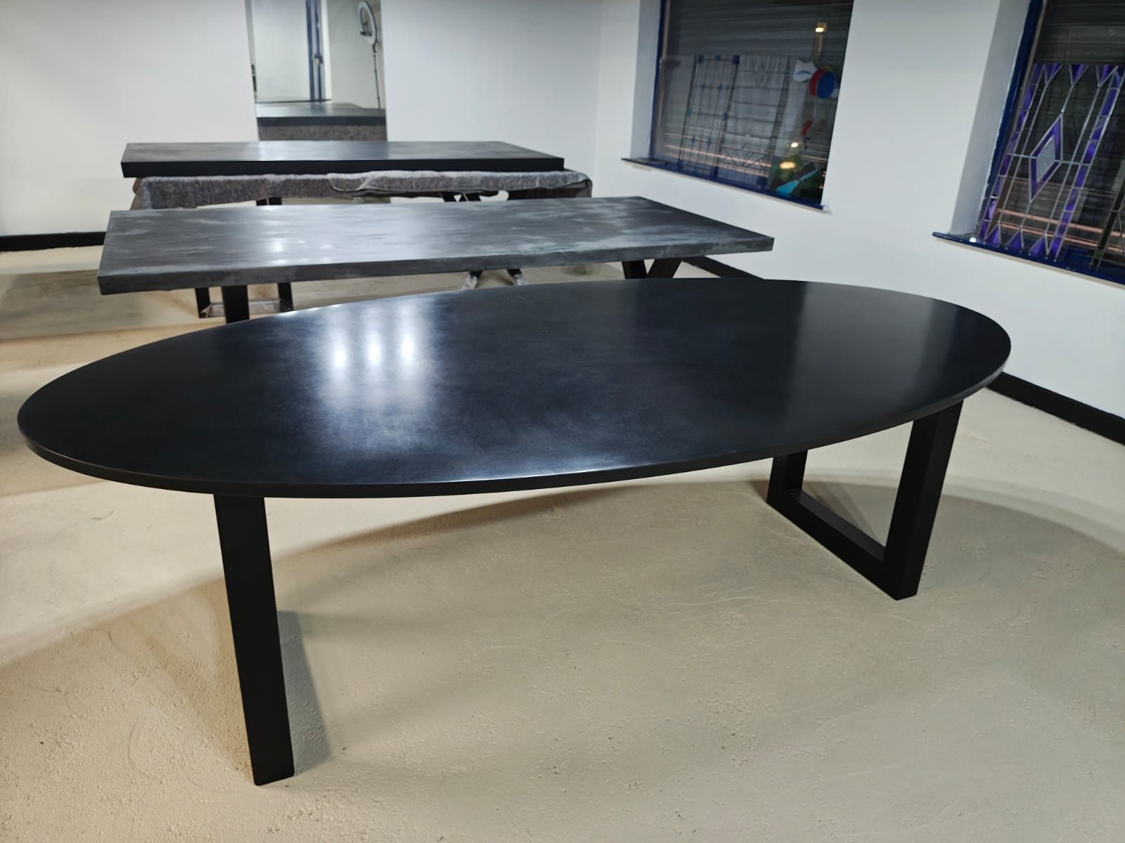 RockVine Artisan Surfaces Black polished concrete dining table in a room with white walls and tiled floor